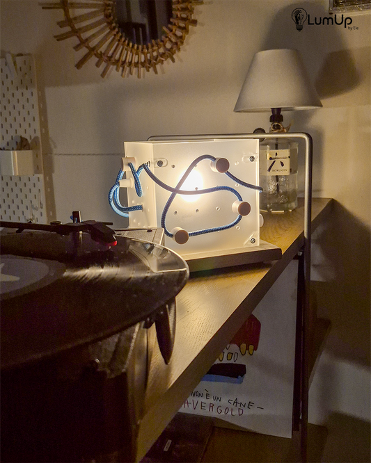 Lampada artigianale realizzata con lastre di metacrilato e legno di recupero.
Colore Trasparente satinato - cavo tessile bianco e azzurro - immagine intera