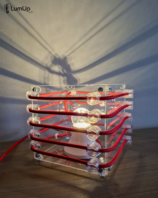 Lampada artigianale realizzata con lastre di metacrilato.
Colore Trasparente lucido - cavo tessile rosso - immagine intera