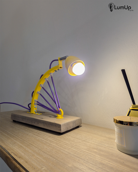 Lampada artigianale realizzata con parte di ruota di bicicletta e legno di recupero.
Colore Giallo - Cavo tessile viola - Punto luce snodato - immagine intera