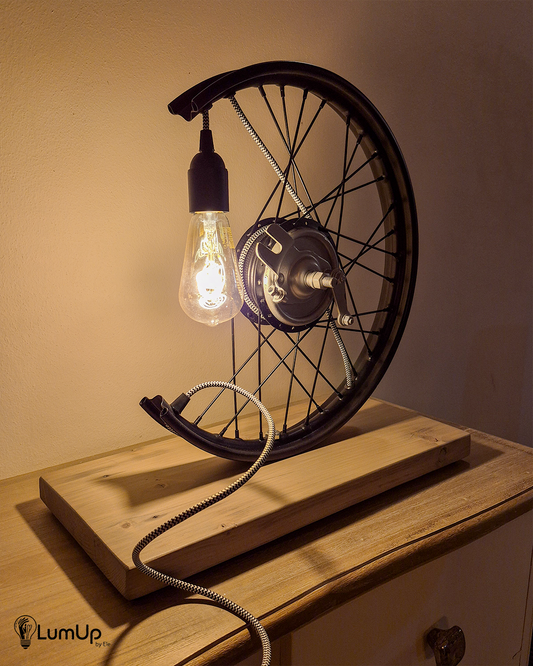 Lampada artigianale realizzata con ruota di motocicletta e legno di recupero.
Colore Nero - Lampadina stile vintage - Cavo elettrico bianco e nero - immagine intera