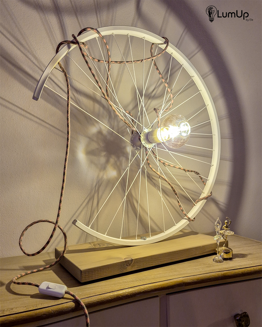 Lampada artigianale realizzata con ruota di bicicletta e legno di recupero.
Colore Bianco - Lampadina stile vintage - Cavo elettrico rosa e salvia - immagine intera
