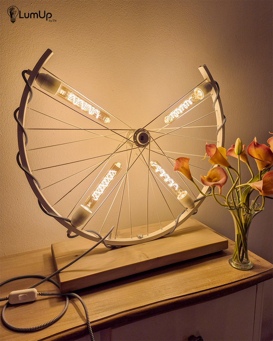 Lampada artigianale realizzata con ruota di bicicletta e legno di recupero.
Colore Bianco - Lampadine stile vintage - Cavo elettrico bianco e nero - immagine intera