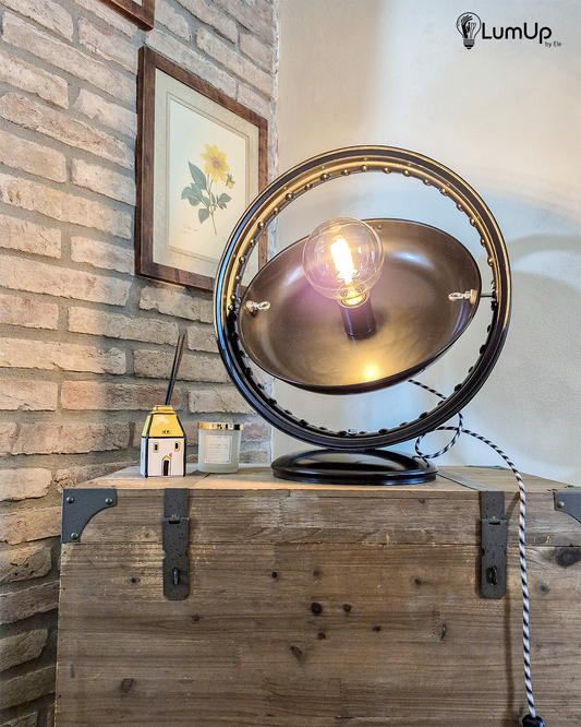 Lampada artigianale realizzata a partire da una ruota di motocicletta e un vecchio piatto di una bilancia.
Colore Nero - Cavo tessile a bianco, nero e grigio - Piatto rotante - immagine intera