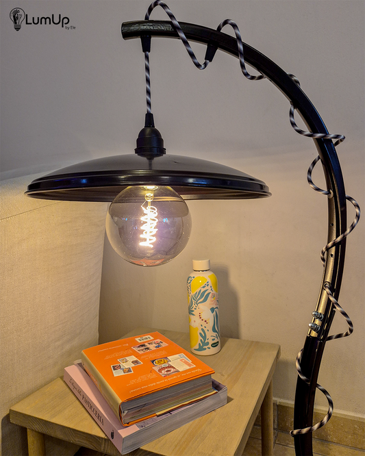 Lampada artigianale realizzata a partire da parti di ruota di bicicletta e un piatto metallico.
Colore Nero - Cavo tessile a bianco, nero e grigio - immagine intera