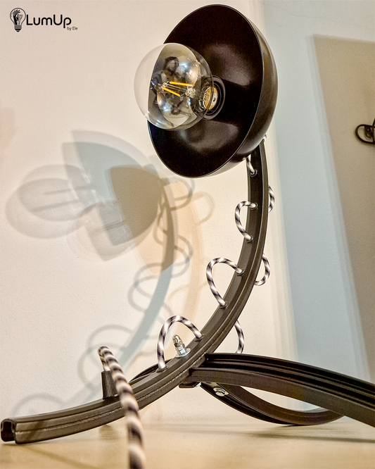 Lampada artigianale realizzata a partire da parti di ruota di bicicletta e una ciotola di metallo.
Colore Nero - Cavo tessile a bianco, nero e grigio - immagine intera